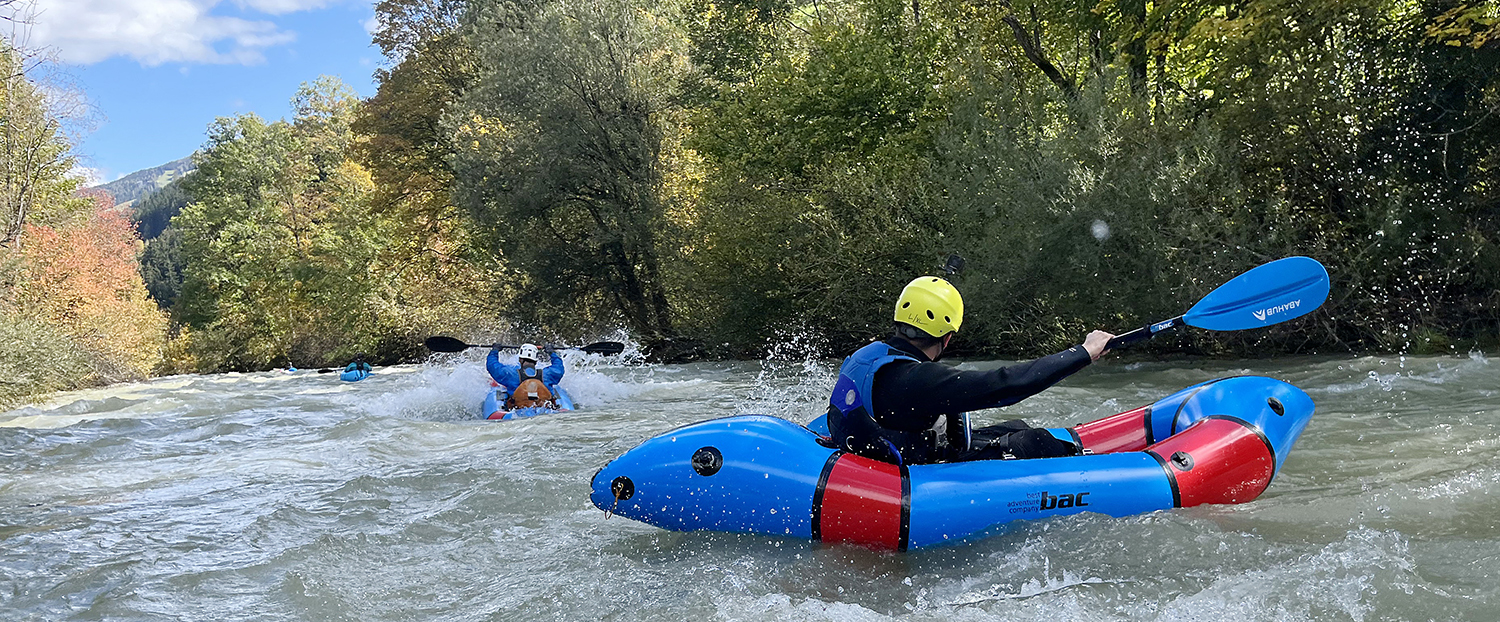 Auf dem Fluss macht eine Gruppein einem Packraft eine Packraft Tour.